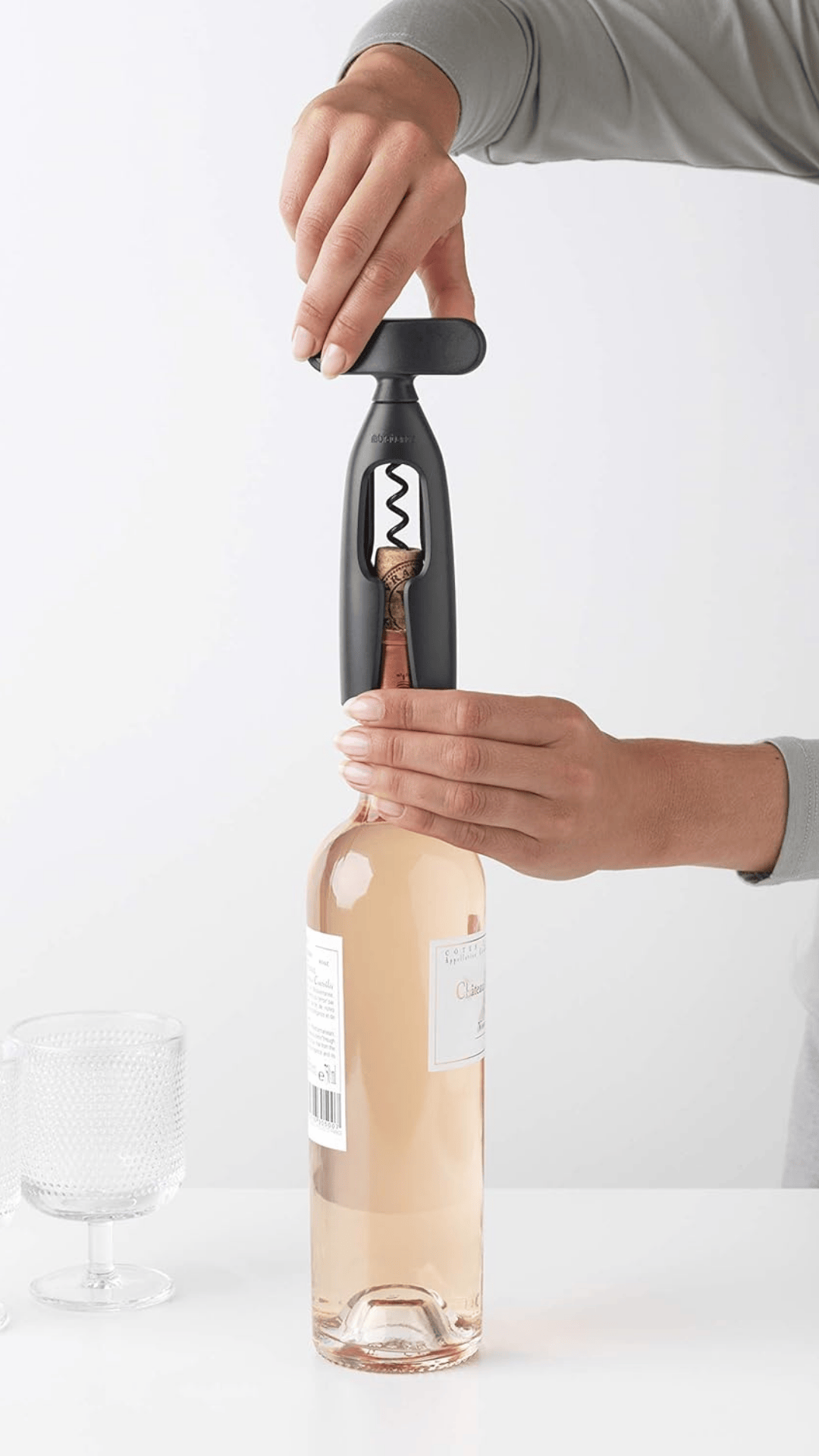 Persona abriendo una botella de vino con un sacacorchos Brabantia Tasty+