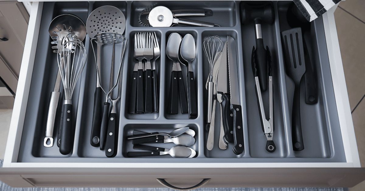 Un cajón de cocina lleno de utensilios y cubiertos