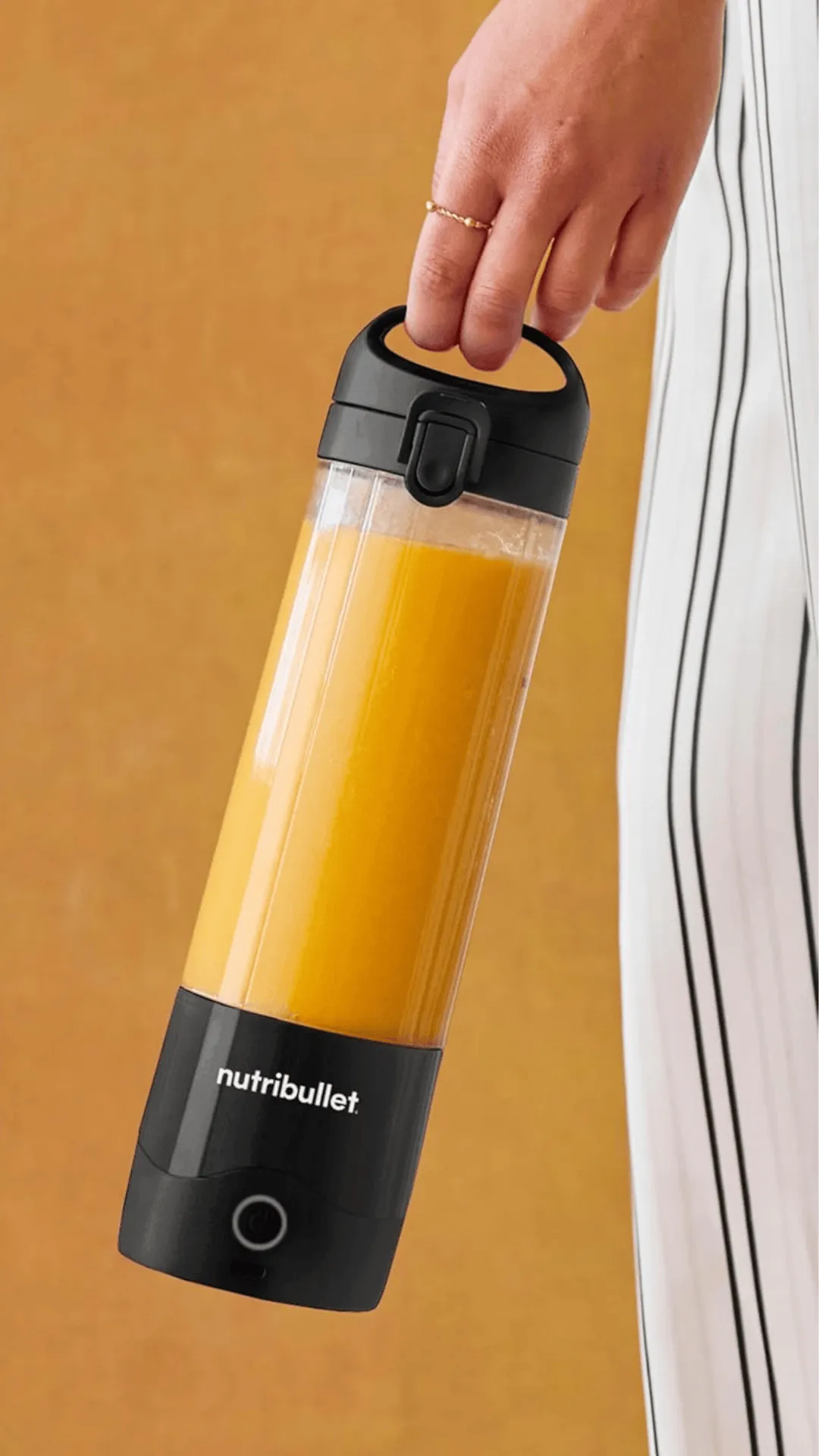 Persona sosteniendo desde el asa la licuadora portátil Nutribullet